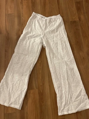 Vita broderade linnebyxor H&M XS - Säljer ett par vita linnebyxor från H&M i storlek XS. Byxorna har broderade blommor, snöre att knyta med i midjan och är tillverkade i 100% bomull. De har en relaxed, wide fit och är perfekta för sommardagar. Endast använda 1-2 gånger!💕
