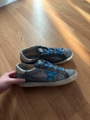 Blå glittriga golden goose superstars skor - Blå glittriga golden goose superstars skor. Andvända i gott skick, ingen större defekt! Storlek 37