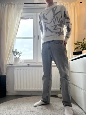 Grå raka jeans i straight fit - Säljer ett par grå jeans med rak passform och klassisk femficksdesign. Jeansen har en enkel look utan slitningar och är tillverkade i denim. Perfekta om du gillar en clean och avslappnad stil.
