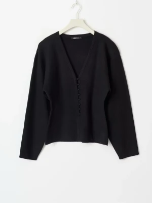 Svart kofta med knappar  - Stilren svart kofta med v-ringning och dekorativa knappar framtill. Långärmad modell i mjukt material som passar perfekt till lager på lager. Enkel att matcha med olika outfits för en clean look.