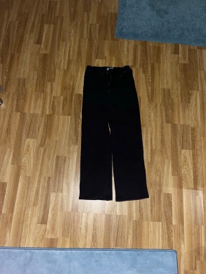 Svarta raka byxor från Lindex - Svarta byxor från Lindex i storlek 146. De har raka ben och klassisk femficksdesign med två bakfickor. Materialet är mjukt och känns som bomull, perfekt för dig som gillar enkel och stilren look.