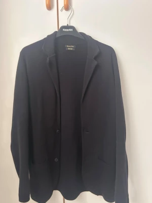 Mörkblå cardigan från Massimo dutti  - Kavajen/cardiganen har enkelknäppning och är långärmad. Materialet är mjukt och känns lite som stickad ull, perfekt för en clean och stilren look. Nypris 1300kr