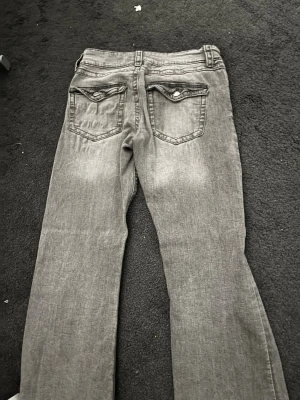 Grå jeans från Gina Tricot, storlek 164 - Säljer ett par grå jeans från Gina Tricot i storlek 164. Jeansen har klassisk femficksmodell med snygga ficklock bak och raka ben. Materialet är mjukt jeans-tyg och färgen är en tvättat i grå färg   
