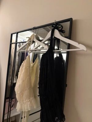 Plisserad topp Shein svart & vit S - Två snygga plisserade toppar från Shein i storlek S, en i svart och en i vit. Modellen är croppad med tunna axelband och volangkant nedtill. Tillverkade i mjuk polyester och perfekta för sommarens alla tillfällen.