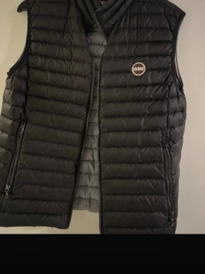 Svart dunväst från Colmar - Säljer en svart dunväst från Colmar i super bra skick. Västen är super fräsch och passar med allt nu inför sommaren i storlek s 