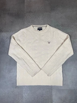 GANT cable-knit sweater - GANT cable-knit sweater — cream / classic knit / size M  Description: Säljer en GANT cable-knit sweater i snygg cream färg. 🧵 Märke: GANT 👕 Storlek: M 🎨 Färg: Cream / off-white 📌 Design: Klassisk flätstickad tröja 📍 Skick: Mycket bra — se bilder!  Beskrivning: • Klassisk cable-knit-stickning ger en tidlös look • Bekväm och varm — perfekt för höst/vinter • Ribbstickade muddar och kant för bra passform • Inga fläckar, noppor eller skador (kon