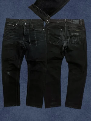 Nudie Jeans Selvedge - Säljer nu dessa svarta Selvedge jeansen från Nudie. Bra skick, reparerade på vissa ställen. 32/30, Längd: 100, midja: 43, fotvidd: 18, lår: 25 Skriv vid frågor