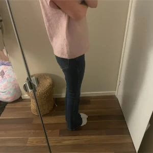 Mörkblå bootcut jeans - Snygga mörkblå jeans med bootcut-modell och klassisk femficksdesign. Jeansen har en normal passform och är tillverkade i ett mjukt denimtyg som sitter skönt på kroppen. Perfekta för dig som gillar en tidlös och avslappnad stil. OBS lånade bilder skorv privat för fler bilder