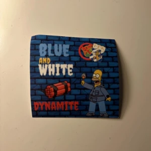 IFK Göteborg klibbor 50st - IFK klibbor med blå och vit färg, inspirerad av IFK Göteborg. Tryck med Homer Simpson, dynamit och texten 'Blue and White Dynamite' mot en blå tegelvägg.  Har 50st