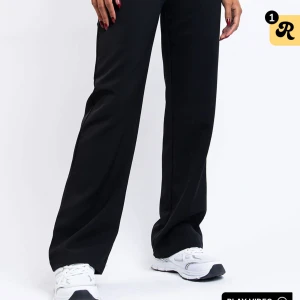 Svarta kostymbyxor 36 Tall - Svarta kostymbyxor med vida ben och hög midja. Klassisk look med bälteshällor och raka pressveck längs benen. Perfekta för en clean och stilren outfit. Passar dig som gillar längre byxor och vill ha en avslappnad men dressad stil. Säljes då de är förstora för mig i midjan.