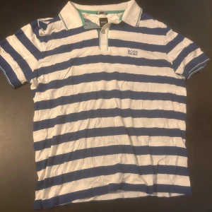 Randig pikétröja från Hugo Boss - Snygg pikétröja från Hugo Boss. Står ingen storlek men skulle säga XS/S.