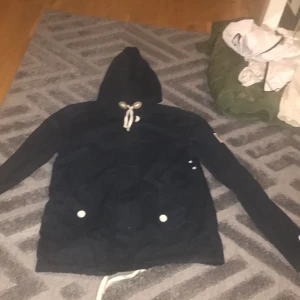 Svea jacka - En jacka med märket Svea, blå med amerikansk flagga på vänsterarmen,storleken M 