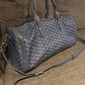 Weekendbag/duffelbag - Snygg och rymlig weekendväska  i grått med deras ikoniska grafiska mönster. Väskan har både handtag och justerbar axelrem, silverfärgade detaljer och dragkedja. Perfekt för resor eller när du vill ha med dig lite extra grejer. I princip nya använd 1-2 gånger säljs för 2800kr men priset går att diskutera.