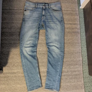 T/J Evolve Jeans - Snygga ljusblå jeans från T/J med klassisk femficksdesign och brunt läderpatch bak i midjan. Jeansen har smal passform och raka ben, tillverkade i mjukt denimtyg. Perfekta för dig som gillar en clean och stilren look. Väldigt bra skick, enda tecken på användning är att de är lite urtvättade. Fråga gärna om ni har några funderingar. /Isak
