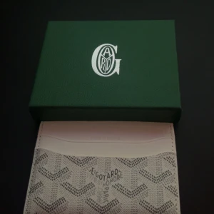 Goy4ard korthållare - Exklusiv korthållare från Goy4rd i vitt med deras ikoniska grafiska mönster. Slimmad design med flera kortfack och präglad logotyp framtill. Tillverkad i skinn och canvas, perfekt för dig som vill ha något stilrent och lyxigt i fickan.