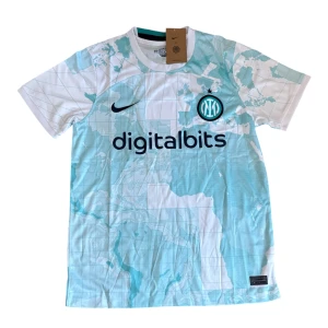 Inter Milan bortatröja 2022/23 Nike - Inter Milan bortatröja från säsongen 2022/23 med unik världskarta-mönster i ljusblått och vitt. Tröjan har korta ärmar, broderat klubbmärke och Nike-logga samt tryckta sponsorer. Tillverkad i lätt och ventilerande funktionsmaterial.