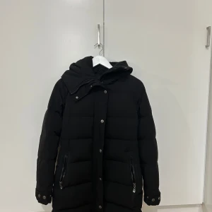 Svart pufferjacka från Hollies - Säljer en vinterjacka från hollies som jag använt en vinter bara. Storlek 36. Nypris 5 199 kr.