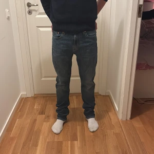 Levi's 502 blå jeans W30 L32 - Säljer ett par klassiska Levi's 502 jeans i blå denim. Modellen har rak passform med normal midja och fem fickor. Jeansen har snygga kontrastsömmar och den ikoniska Levi's-lappen bak i midjan. Perfekta för en avslappnad och stilren look. De är i bra skick då de är använda en gång.