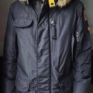 Mörk blå  Parajumpers med fuskpäls - En jätte fin jacka som håller dig varm under hela vintern. Äkta päls har använt den i 2 månader annars är den helt ny. 