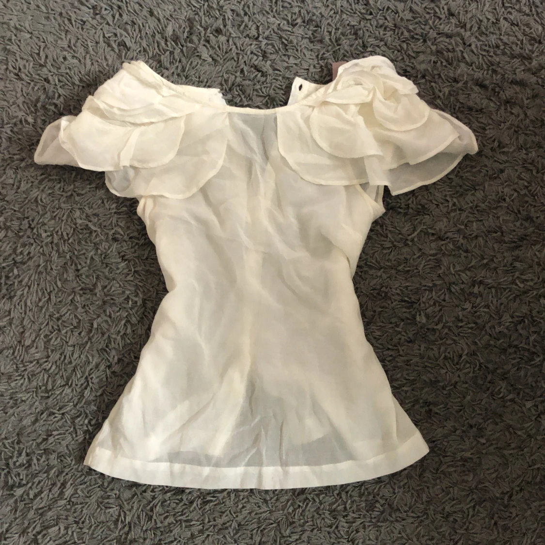 Vit blus med volangaxlar