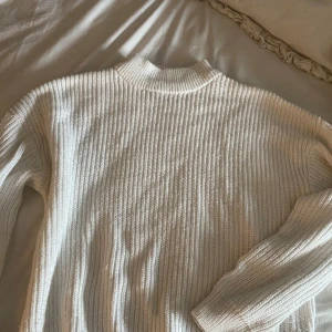 Vit stickad tröja från FB Sister XS - Säljer en ribbstickad vit tröja från FB Sister i storlek XS. Tröjan har hög krage och långa ärmar, perfekt för lager-på-lager. Enkel och stilren design som passar till allt. Materialet är mjukt och skönt stickat.