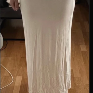 Ljus långkjol från Gina tricot - Supersnygg långkjol från Gina tricot i en ljus,  beige ton. Den är lite genomskinlig. Någon fläck som går bort i tvätten!