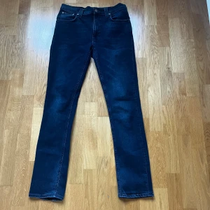 Nudie Jeans - Snygga mörkblå jeans från Nudie Jeans Co medljusblå broderade detaljer på bakfickorna. Dem sitter som slim/straight. Vid snabb affär kan priset diskuteras.
