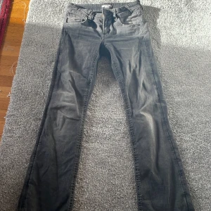 Svarta jeans från Gina Tricot, stl 164 - Svarta jeans från Gina Tricot i storlek 164. Modellen har raka ben och snygga bakfickor med broderad detalj och knapp. Jeansen är i klassisk femficksmodell och tillverkade i ett mjukt bomullstyg med lite stretch.