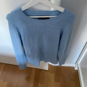 Ljusblå stickad tröja från Vero Moda - Mysig ljusblå stickad tröja från Vero Moda med rund halsringning och ribbade muddar. Perfekt för lager-på-lager och enkel att matcha med jeans eller kjol. Klassisk modell med lång ärm och mjuk känsla.