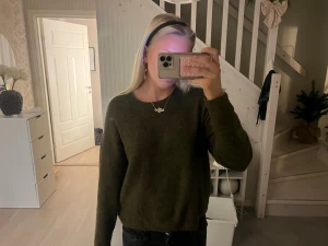 Mörkgrön stickad tröja - Mysig mörkgrön stickad tröja med rund halsringning och långa ärmar. Tröjan har en enkel och clean design, perfekt att slänga på sig när det är kallt ute. Den är lite loose i passformen och känns riktigt skön mot huden.