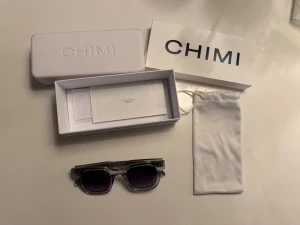 CHIMI transparenta solglasögon - Snygga solglasögon från CHIMI med transparent grå båge och rektangulär form. Glasen är mörka och har en cool gradient-effekt. Kommer med originalfodral, box och putsduk. Perfekt accessoar för att lyfta din stil.