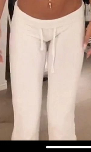 Vita lågmidjade  mjukisbyxor med snörning - Säljer ett par vita mjukisbyxor med snörning i midjan. Byxorna har en rak passform och är perfekta för en chill och avslappnad stil. Mjukt material som känns skönt mot huden och passar till alla dina favorit-hoodies.
