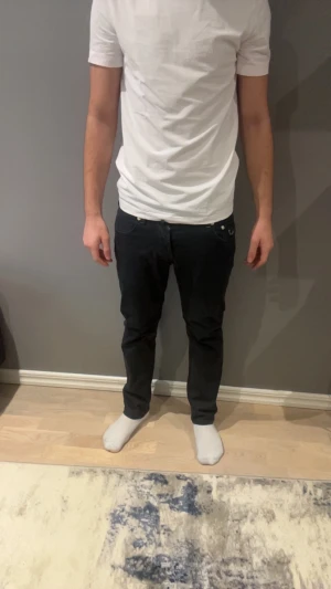 Svarta jeans från Jacob Cohën - Säljer ett par svarta jeans från Jacob Cohën med snygga silverfärgade knappar och detaljer. Jeansen har klassisk femficksdesign, raka ben och normal passform. Innerfickorna har tryckt logga och insidan har coola textdetaljer. Perfekta för dig som gillar stilrena och exklusiva jeans.OBS!! De har ett pytte ytte litet hål vid skrevet!!