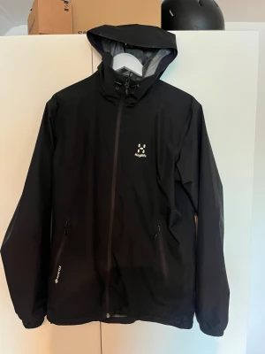 Svart vindjacka från Haglöfs, S - Svart Gore-Tex vindjacka från Haglöfs i storlek S. Är stor i storleken så passar även M och möjligtvis L. Jackan är i ett fint skick och köptes ny i Februari 