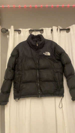  The North Face  - Säljer en svart dunjacka från The North Face i storlek M men passar för dem som har S då jag har det. Jackan har hög krage, dragkedja framtill och justerbara snören i nederkant. Klassisk pufferstil med logga på bröstet och ryggen. Perfekt för kalla dagar och riktigt snygg streetstil. Priset kan diskuteras💗
