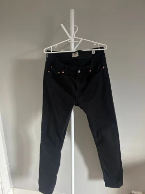 Svarta jeans från Morris, storlek 30/32 - Säljer ett par svarta jeans från Morris i storlek 30/32. Klassisk femficksmodell med smal passform och snygga kopparfärgade nitar. Jeansen har en stilren look och är tillverkade i mjuk bomullsblandning för skön känsla.