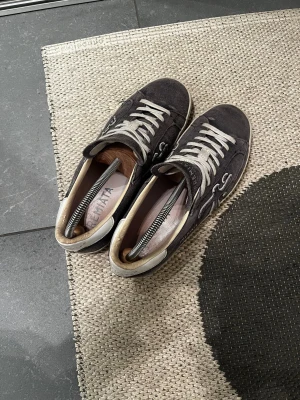 Premiata blå mocka sneakers strl 41 - Snygga sneakers från Premiata i blå mocka med vita detaljer och snörning. Klassisk låg modell med rund tå och platt sula. Logotypen är broderad på sidan och märket syns på plösen. Insidan är ljus och skön mot foten. Perfekt för dig som gillar stilrena och coola skor. Stor i storlek, passar 42