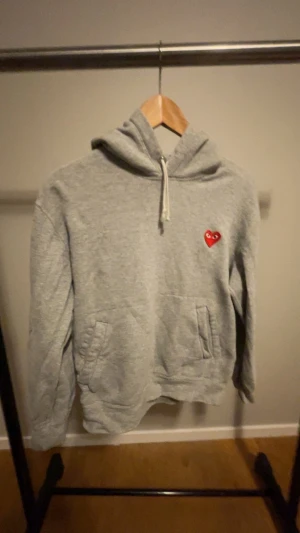 Grå hoodie från Comme des Garçons - Hål på ena armbågen.