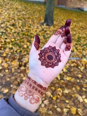 Mandala henna - Snyggt guldigt länkarmband som syns på handleden, perfekt för dig som gillar stilrena detaljer. Armbandet matchas med mörkbrun henna i blommigt mönster på handen och fingrarna, vilket ger en unik och personlig touch.