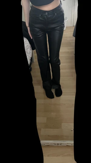 Svarta straight byxor i skinnlook - Snygga svarta byxor från Dilvin Basic. Materialet är syntet med mjuk insida,          aldrig använt, jag är 166 cm lång 