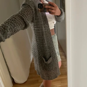 Grå grovstickad kofta med fickor - Mysig grå grovstickad kofta med lång ärm och öppet avslappnat fall. Koftan har stora fickor framtill. Perfekt att slänga på sig över en t-shirt nu i höst! - defekt: nopprig