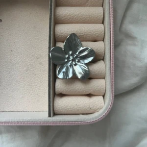 Stor blomring - Säljer en cool och unik ring i form av en stor blomma i silverfärgad metall. Ringen har fem tydliga blomblad med fina detaljer som ger en snygg och modern look. Perfekt statement piece för dig som vill sticka ut.