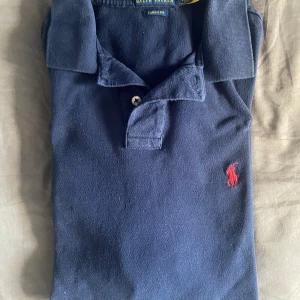 Mörkblå pikétröja från Ralph Lauren - Fin Ralph Lauren Pike i mörk blå, otroligt fint skick inga märken och skador