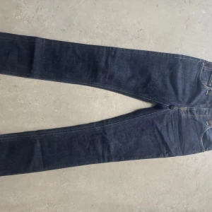 Mörkblå jeans från Nudie Jeans - Säljer ett par mörkblå nudiejeans i storlek 29/32. Jeansen är passar 160-170 i längden och har en rätt så tajt passform runt benet. Hör av dig vid minsta lilla fråga.😀