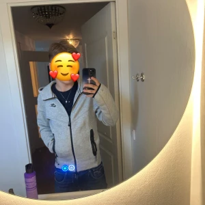 Grå zip-hoodie från Nike XS - Säljer en grå zip-hoodie från Nike med svart logga på bröstet och svarta detaljer vid dragkedja och fickor. Jackan har huva, lång ärm och är tillverkad i mjuk bomullsmix. Perfekt för chill eller träning, riktigt clean look.
