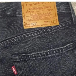 Levi's 501 svarta jeans W29 L32 - Säljer min killes jeans💗Klassiska svarta Levi's 501 jeans med rak passform och femficksdesign. Jeansen har en snygg mörk tvätt, ikonisk läderpatch bak och röd Levi's-tag vid bakfickan. Tillverkade i slitstarkt denim av bomull. Perfekta för en stilren och tidlös look.