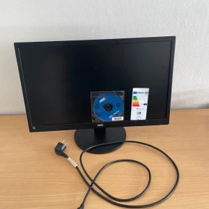 AOC E2470SWHE 24" LED Monitor - AOC E2470SWHE 24" LED-skärm med Full HD-upplösning. Utrustad med 2x HDMI, VGA (D-Sub) och ljudutgång. Energisnål och i gott skick, komplett med strömkabel och installationsskiva. Perfekt för både arbete och spel. Inga synliga defekter eller repor.