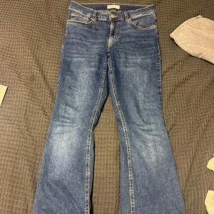 Blå bootcut jeans från Gina Tricot  - Snygga blå jeans från Perfect Jeans i klassisk bootcut-modell. Jeansen har fem fickor, normalhög midja och slitningar för en cool look. Tillverkade i mjukt denimtyg med kontrastsömmar och dragkedjegylf.