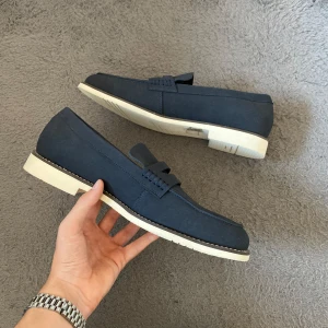 Mörkblå loafers med vit sula - Helt nya mörkblå loafers i storlek 46 som kommer med helt nya 5-pack loaferstrumpor i vit färg 