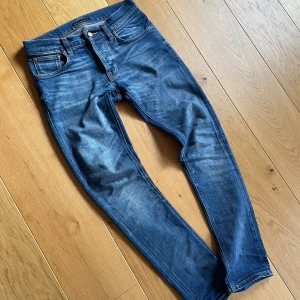 TVÄR FETA NUDIE GRIM TIM - Säljer ett par riktigt feta nudie jeans i modellen Grim Tim. Jeansen har en snygg tvätt som passar året runt! Storlek 29/32! Skriv vid funderingar!
